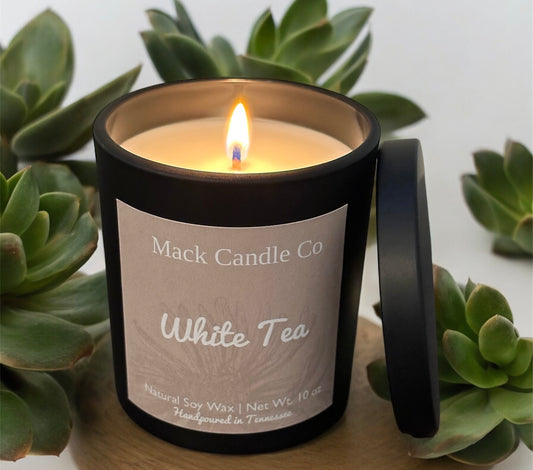 Luxury White Tea Soy Candle, comes in a matte black jar filling the space of a bedroom. Non toxic clean burning handpoured in small batches in Nashville Tennessee. 