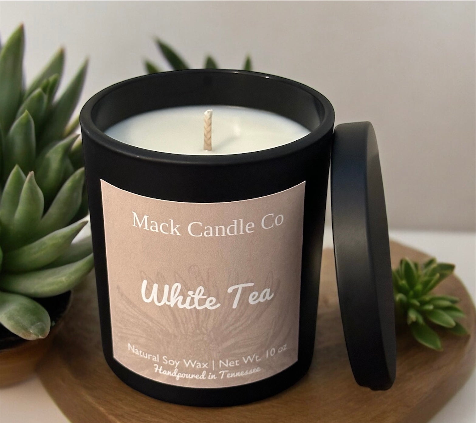 Luxury White Tea Soy Candle, comes in a matte black jar filling the space of a bedroom. Non toxic clean burning handpoured in small batches in Nashville Tennessee. 